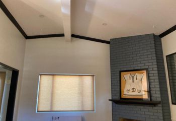 Modern roller shades for windows filtering daylight in an El Cajon living room with grey brick wall.