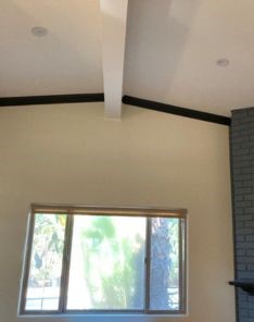 Close-up of custom window shades installed in El Cajon living room window beside brick fireplace.
