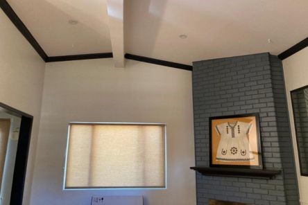 Modern roller shades for windows filtering daylight in an El Cajon living room with grey brick wall.
